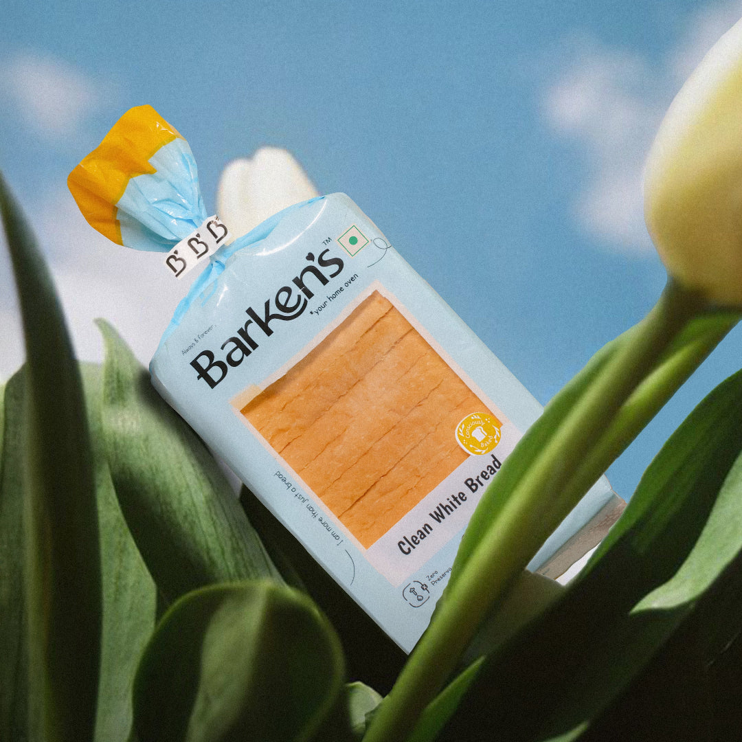 Clean White Bread by Barken’s placed in blooming tulips under a clear sky, representing freshness and purity of ingredients.